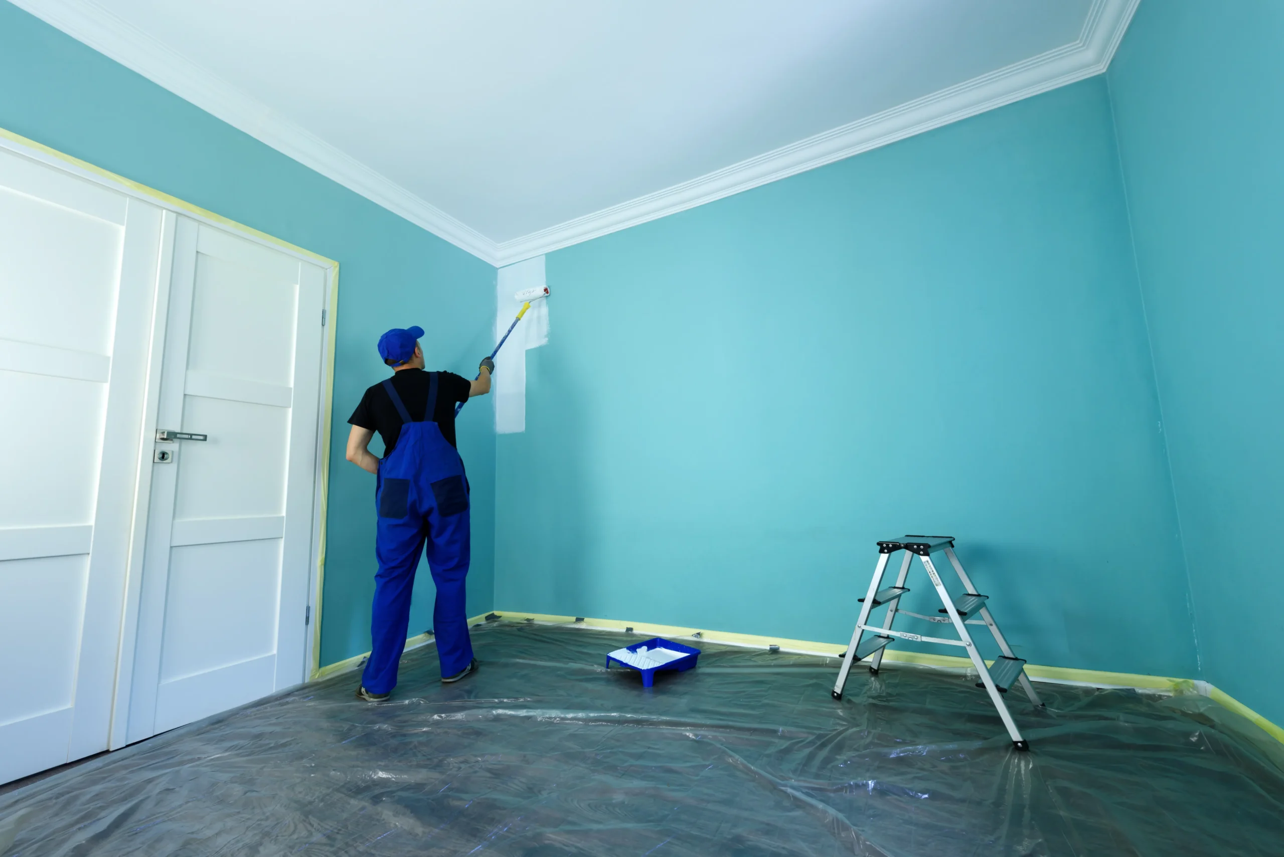 Professional painter applying paint with a roller for smooth wall finish.